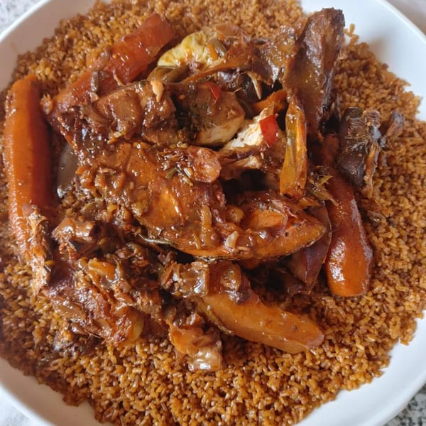 Senegalese Thieboudienne, a dish of fish, vegetables, and rice, served in a white bowl.