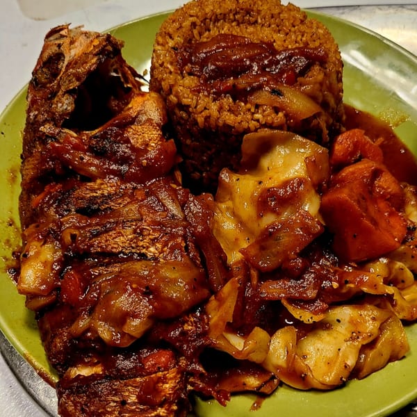 Senegalese Thieboudienne with whole fried fish, rice, and vegetables in a rich sauce.
